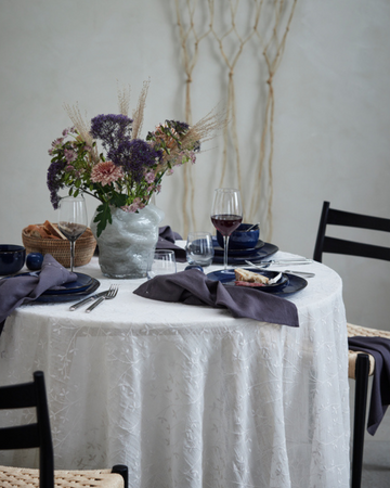 En romantisk Valentinsdag-borddekking med røde roser, levende lys og elegant servise som skaper en koselig og kjærlighetsfull atmosfære.